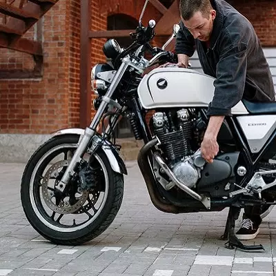 Hombre revisando motor de moto