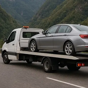 Grúa llevando auto gris por ruta de Tucumán